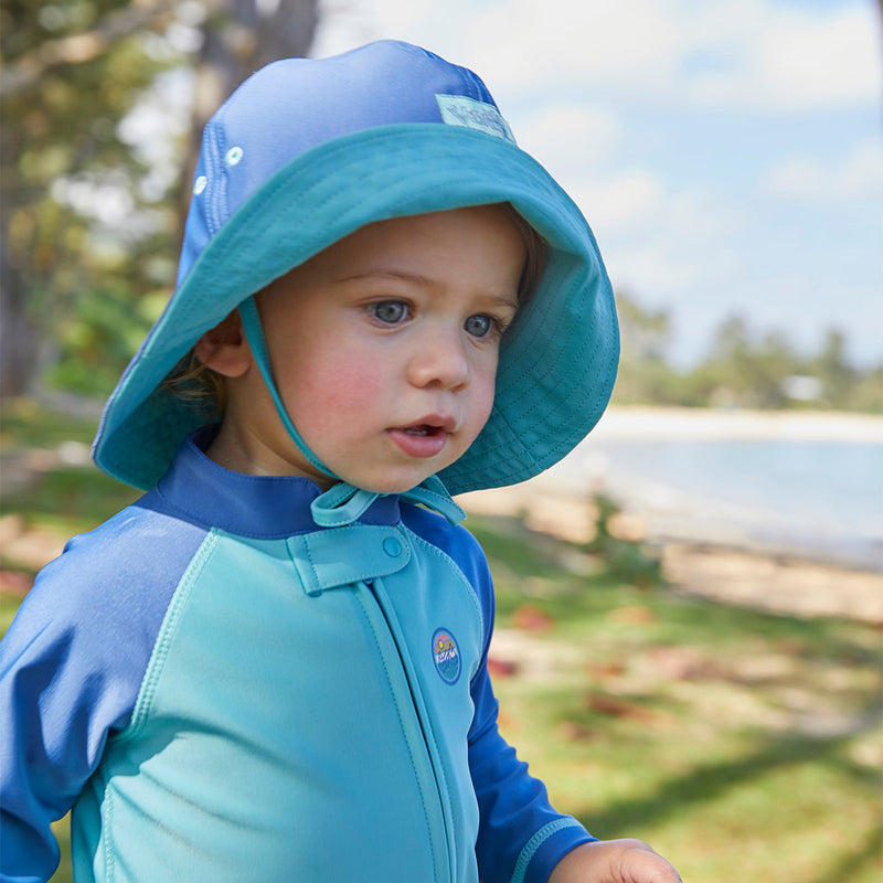 Baby boy in a sun hat on the beach|tropical-cascade