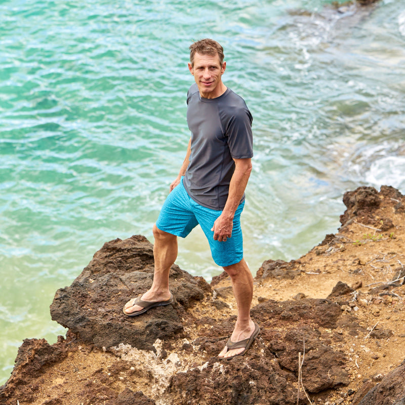 Man exploring the coastline in men's short sleeve swim shirt in charcoal|charcoal