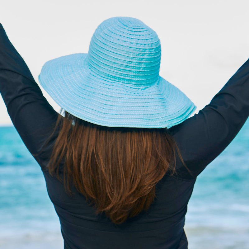 Woman in UV Skinz's wide brim dot sun hat in aqua|aqua